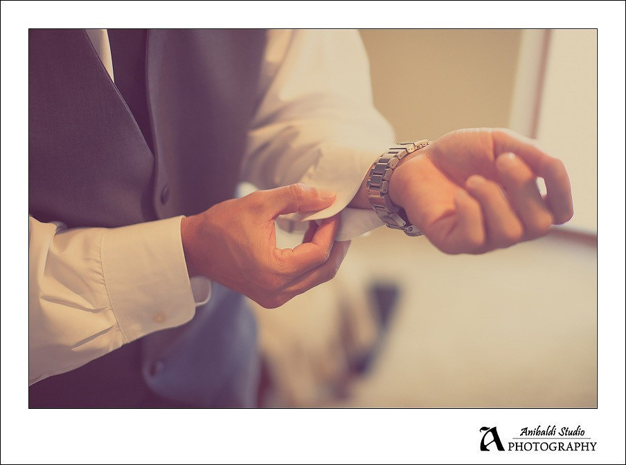 groom putting on cufflinks