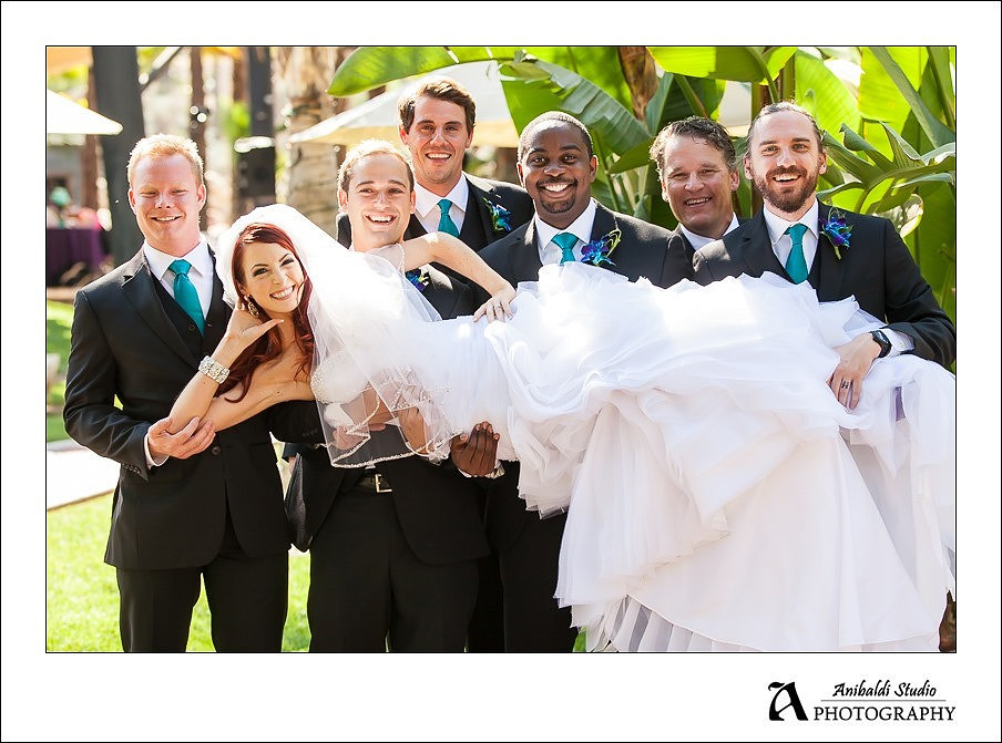 Groomsmen lift bride at stone gardens